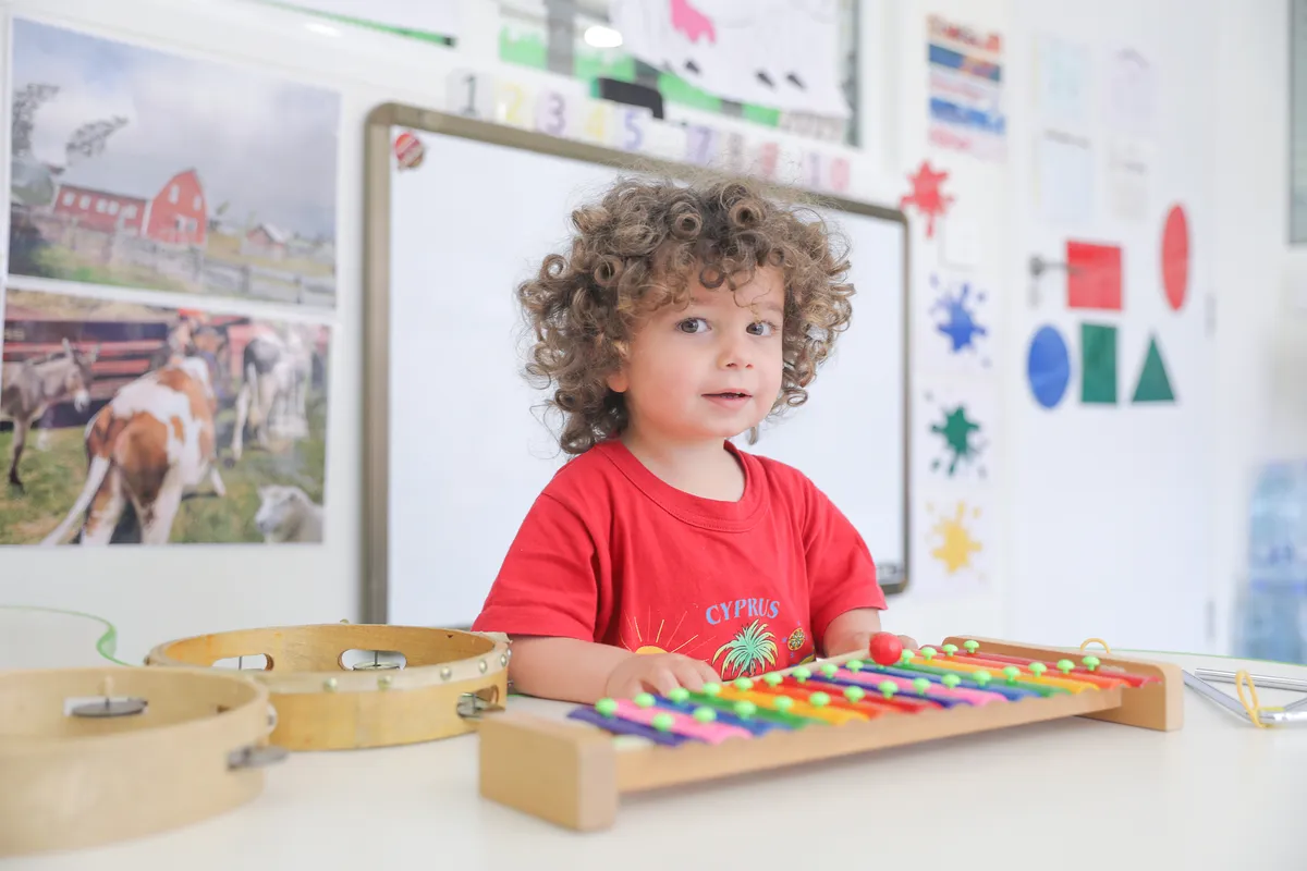 Kindergartner playing a colorful xylophone in the classroom